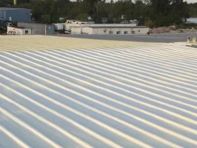 About Maxwell Urethane Roofing showing restored commercial standing seam metal roof coating